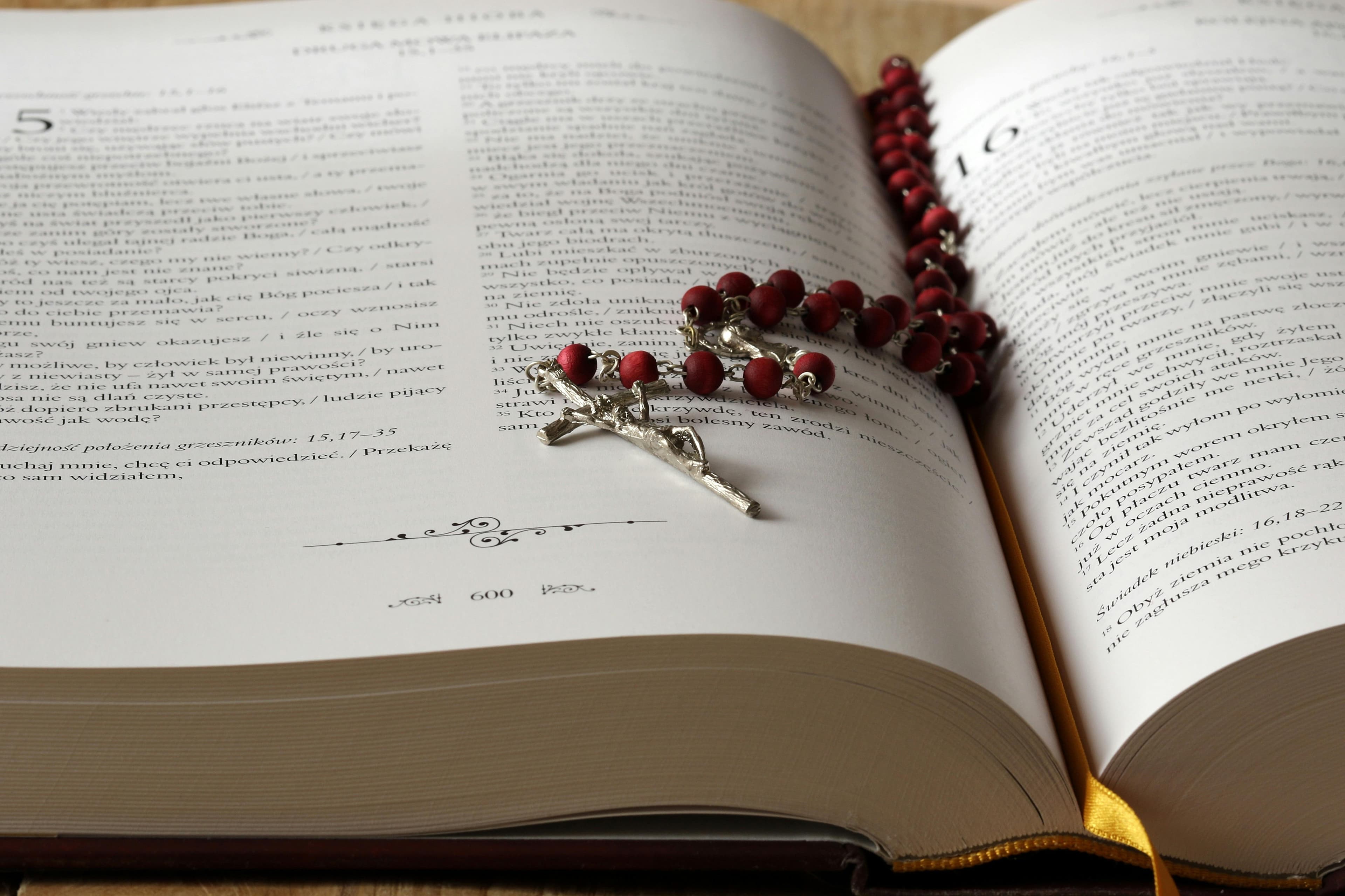 Biblia com umm terço em cima, simbolizando a oração e a leitura espiritual